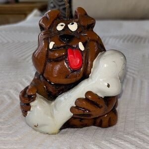 Bulldog holding a giant bone candle.